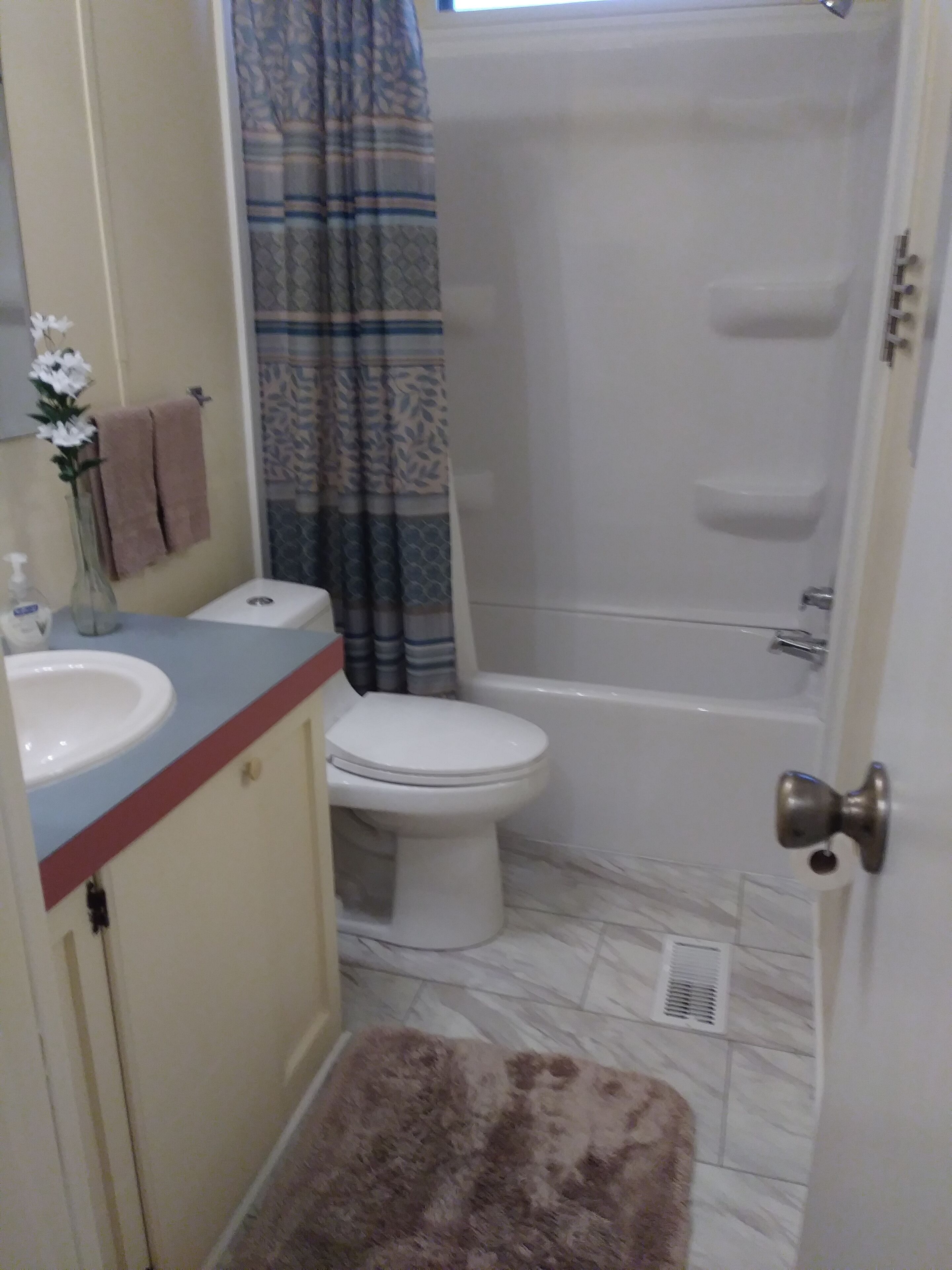 A bathroom with a toilet, sink, and shower.