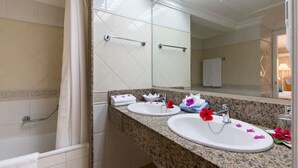 Een badkamer met twee wastafels, een spiegel en een douchehoek.