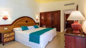 Een hotelkamer met een bed, een houten garderobe, nachtkastjes en een lamp.