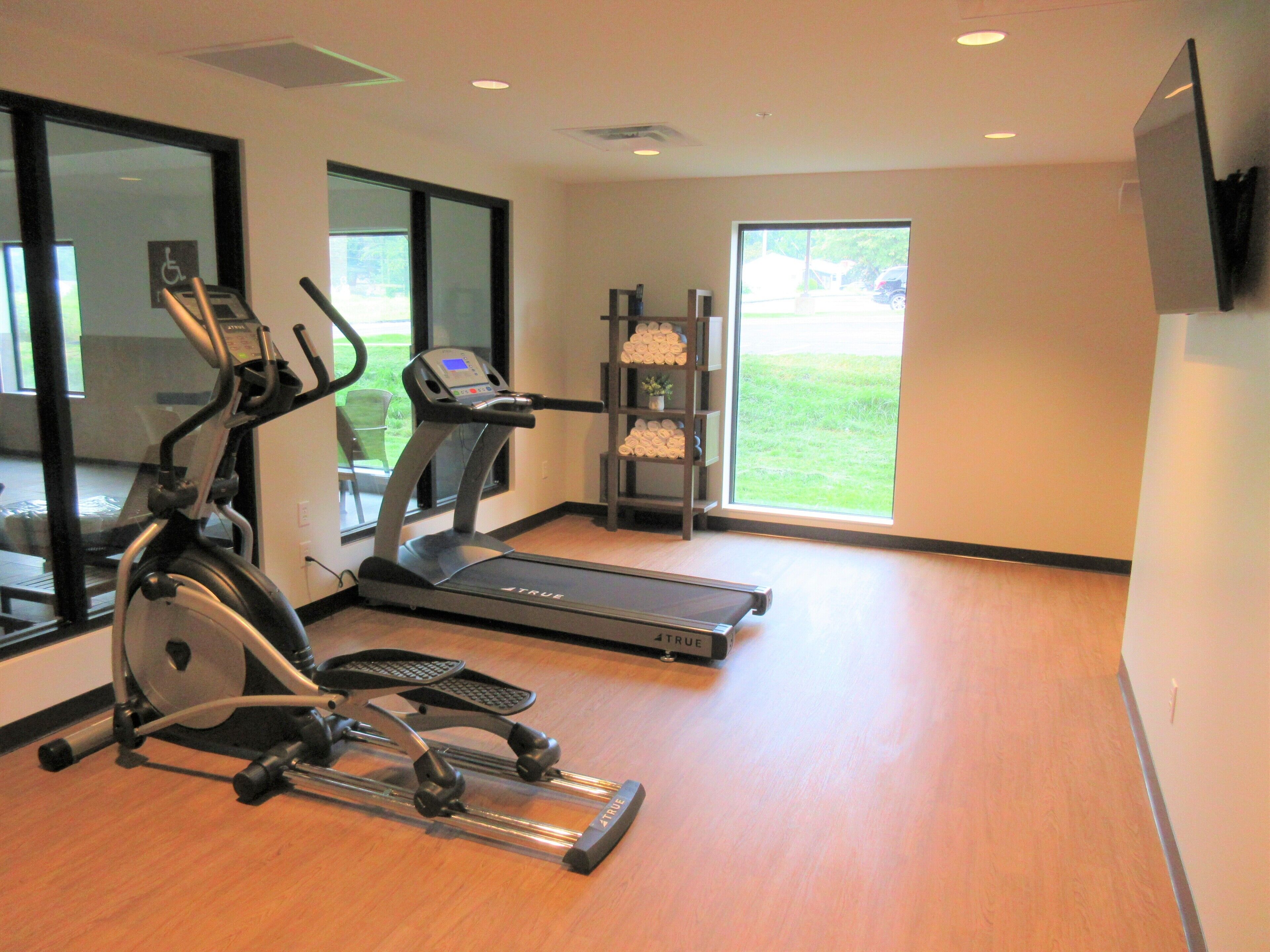 Une salle de sport équipée de tapis de course, d’un vélo elliptique et d’un vélo d’appartement.