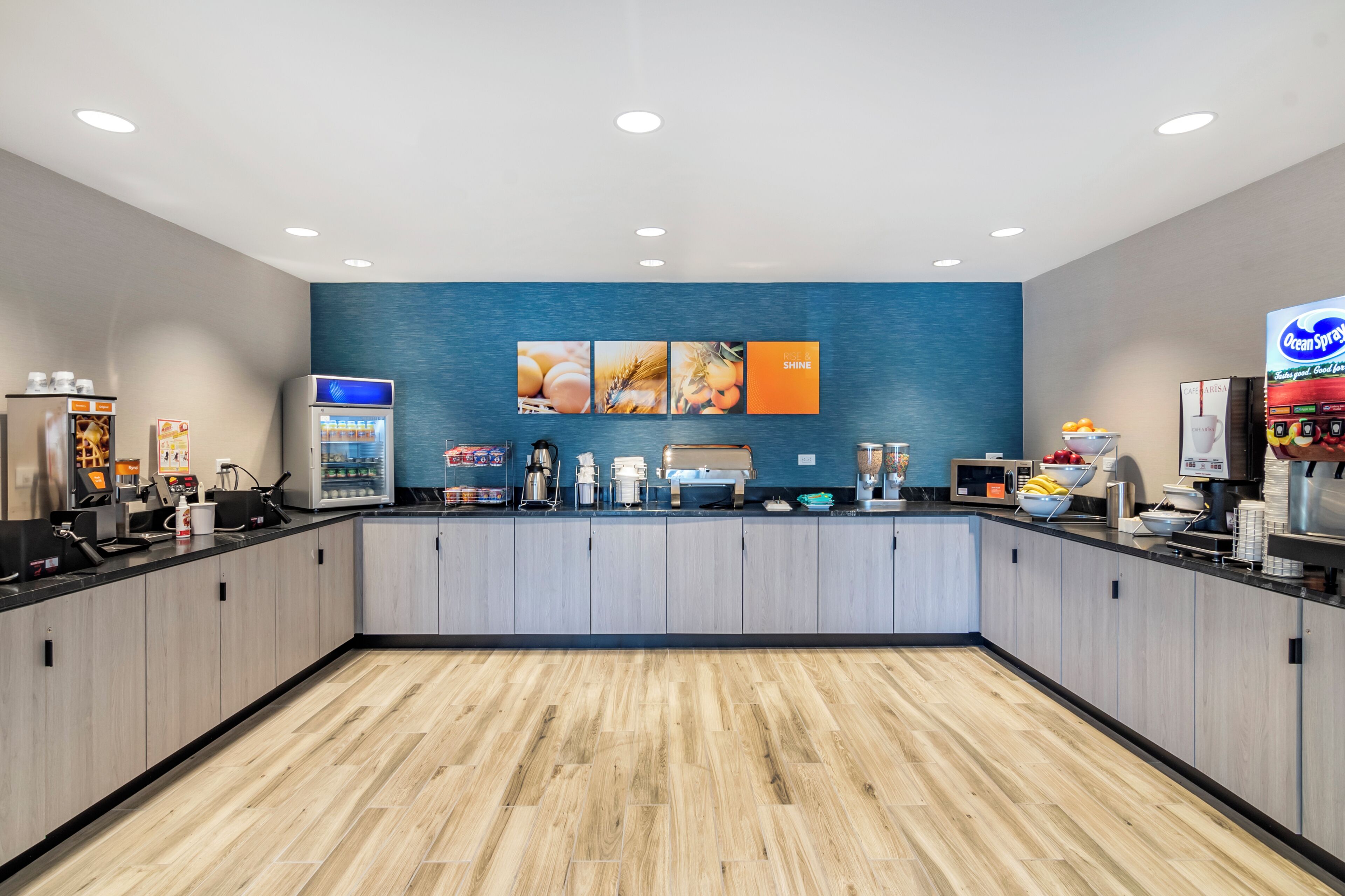 A modern kitchen area with a central island, a refrigerator, a coffee machine, and a microwave.