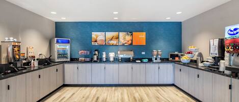 A modern kitchen area with a central island, a refrigerator, a coffee machine, and a microwave.
