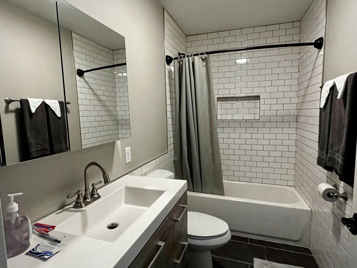 Un bagno moderno con lavandino, water e vasca da bagno bianchi.