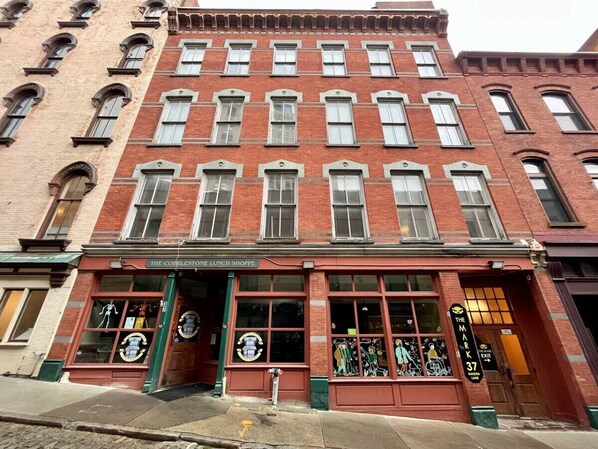 Un edificio de ladrillo rojo con una fachada que dice 'The Cobblestone Lunch Shoppe'.
