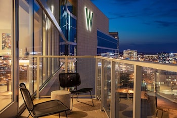 A modern living room with a sofa, armchair, coffee table, and a flat-screen TV. at W Nashville