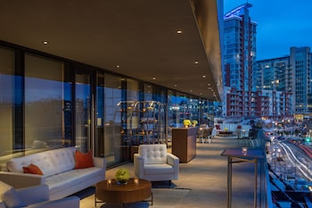 Experience the sleek lobby with a white sofa, round coffee table, and city views through floor-to-ceiling windows. at W Nashville