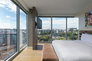 Enjoy a panoramic city view from the large window, featuring a comfortable bed, flat-screen TV, and seating area. at W Nashville