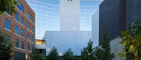 A modern building with a prominent 'W' logo, surrounded by a well-maintained courtyard with seating areas and greenery.