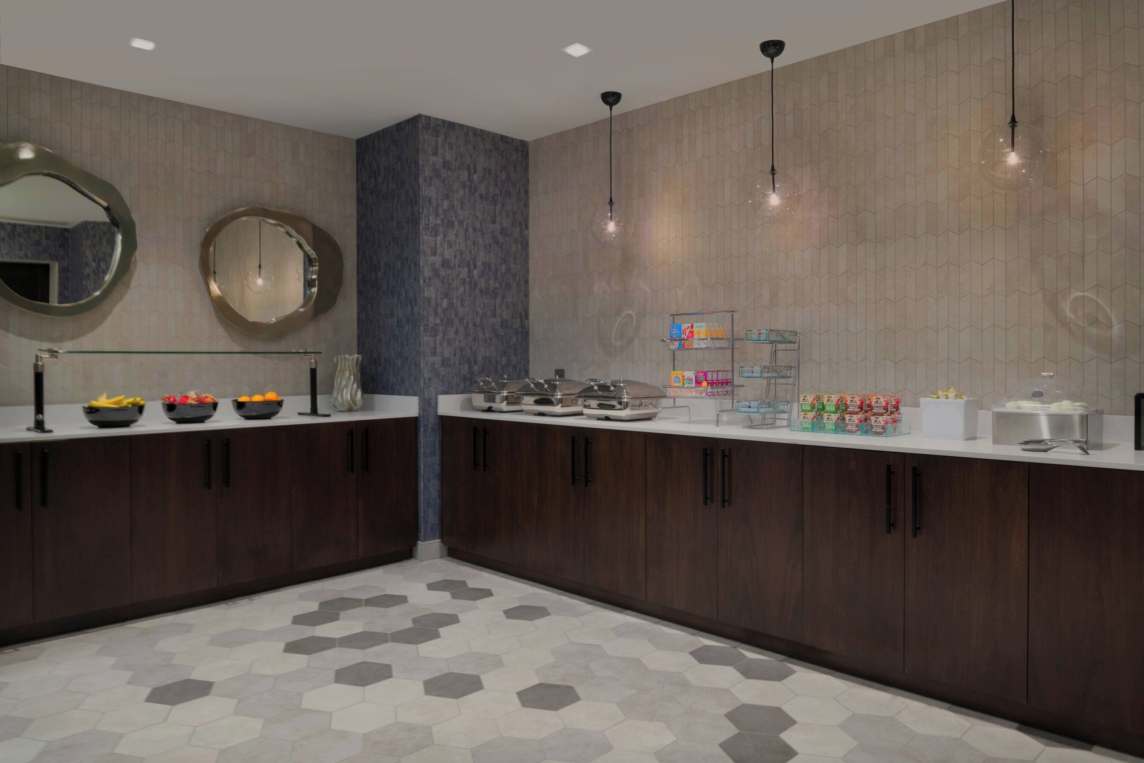 A modern bathroom with dark wood cabinets, a glass countertop, and a hexagonal tile floor.