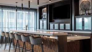 Una cocina moderna con barra, ventanas amplias y un televisor de pantalla plana.