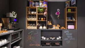 Una barra de desayuno con cajas de cereales, una máquina de café y una pizarra con mensajes motivacionales.