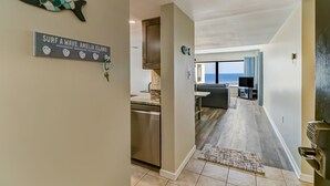 Eine moderne Küche mit Geschirrspüler, ein Essbereich mit Fernseher und Meerblick.