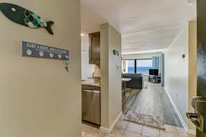 Eine moderne Küche mit Geschirrspüler, ein Essbereich mit Fernseher und Meerblick.
