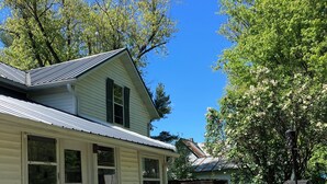 A house with a deck, two blue chairs, a stone planter, and a wooden fence. - Ideal spot minutes from Kickapoo Valley Reserve, Wildcat StatePark & fly fishing (La Farge)