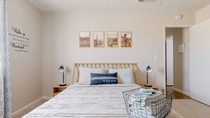 A bedroom with a bed, two bedside tables, a wall with a motivational quote, and three framed pictures. - The Desert Peacock, Hot Tub, Central AC & VIEWS (Yucca Valley)