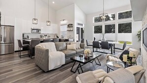 A modern living room with a sofa, coffee table, and dining area. - Coeur d'Alene Townhome Modern New Downtown Shops Beach (CDA)