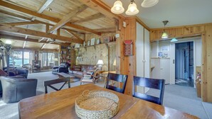 A spacious living area with a wooden ceiling, a dining table with a woven placemat, and a cozy seating arrangement. - 21 Mi to Slopes! Torch Lake Home w/ Private Beach (Rapid City)