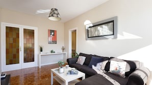 En moderne stue med sofa, sofabord og pendel.
