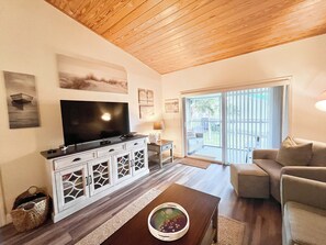 A living room with a flat-screen TV, white cabinetry, a coffee table, and a sofa. - CP 721 1 Bed/1 Bath Condo - Paradise Vacation Rental in Ocean Village (Fort Pierce)