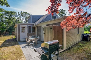 A backyard with a barbecue grill, a small table with chairs, and a shed. - Easy Bike Path Access, Dog Welcome! (Chatham)