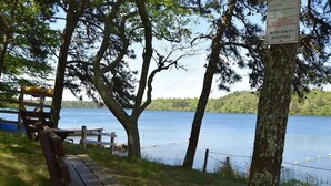 A lakeside bench and picnic table with a sign about water quality. - Beautiful Home Close to Ponds and Beach! (Brewster)