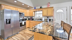 A modern kitchen with wooden cabinets, stainless steel appliances, and a granite countertop. - Cozy Hayesville Retreat w/ Deck & Mtn Views! (Hayesville)