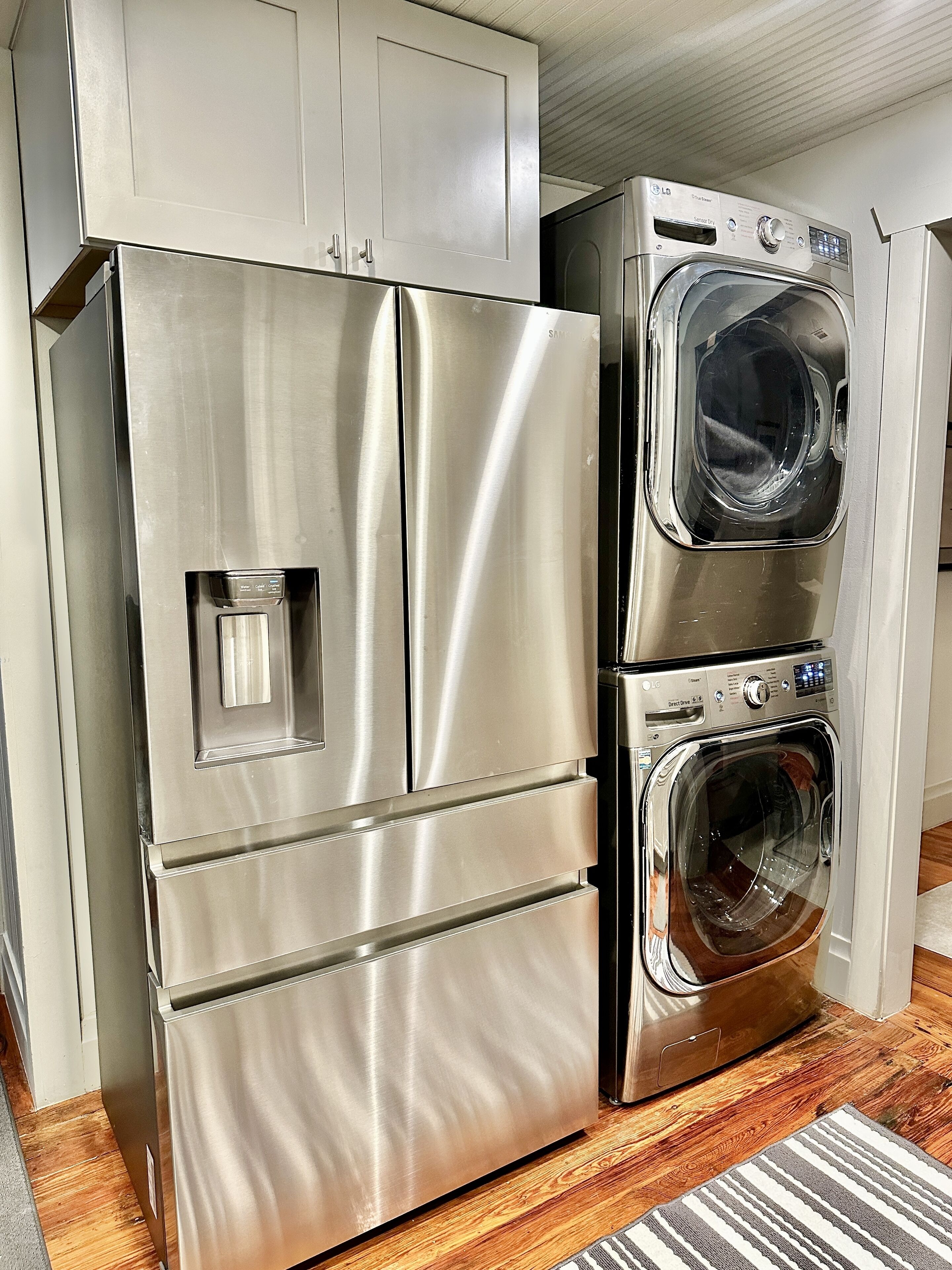 Un refrigerador de acero inoxidable y una lavadora-secadora empotrada en la cocina.