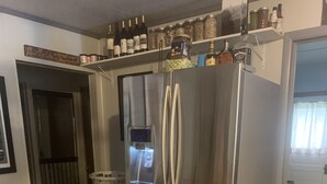 Eine Küche mit einem Edelstahl-Kühlschrank, einem Holzesstisch und Stühlen.