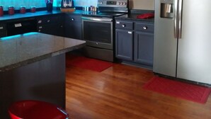 Una cocina moderna con electrodomésticos de acero inoxidable, piso de madera e una isla central.