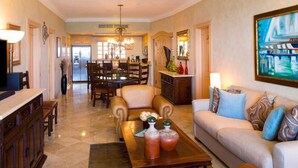 A spacious living room with a sofa, coffee table, and dining area. - Ocean view, swim-up bar, private balcony-Paradise! (Cabo San Lucas)
