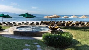 A pool area with lounge chairs and umbrellas, a hot tub, and a view of the ocean. - Ocean view, swim-up bar, private balcony-Paradise! (Cabo San Lucas)