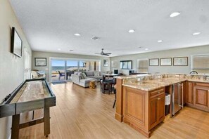 A spacious kitchen with wooden cabinets, a large island, and a dining area with a view.