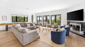 Una sala de estar moderna con un sofá, sillones, una mesa de centro y una chimenea.