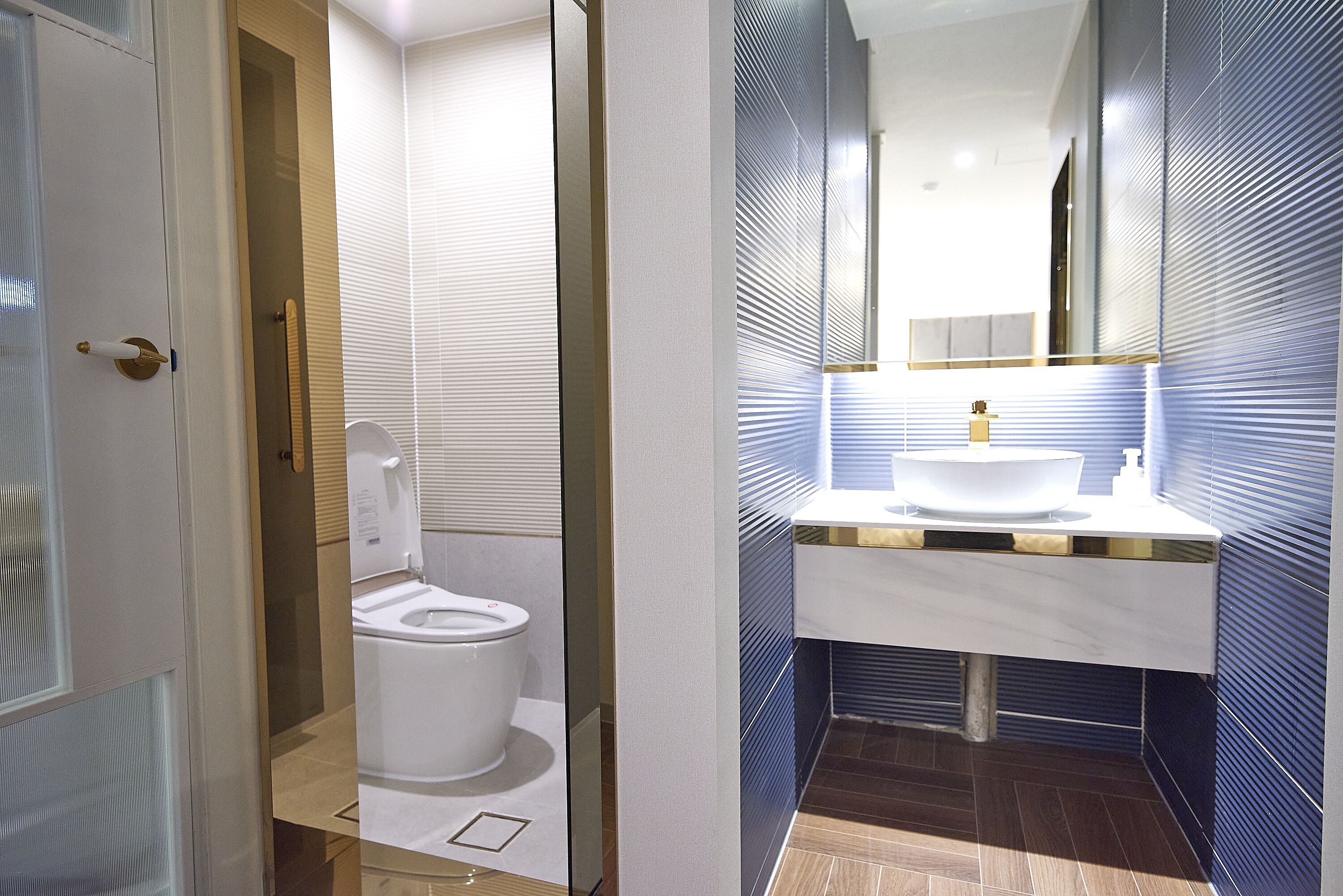 Un baño moderno con inodoro, lavabo y espejo.