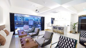 A modern hotel lobby with a seating area, a kitchen, and a large window offering a view of the outside. - Den Basta Signature Hotel (Busan)