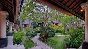 A traditional-style building with a covered walkway, surrounded by lush greenery and a well-maintained garden.
