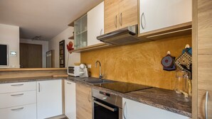 Una cucina moderna con mobili in legno, un lavello in acciaio inossidabile e un forno integrato.