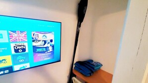 A television mounted on a wall displaying various channels and a remote control on a table. - Bonita-Jamaica Beach w/Pool,Dog Friendly,kayak/pdlebrd,big yard,8min walk 2beach (Jamaica Beach)