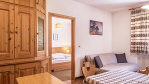 Un dormitorio con una cama, un aparador de madera, una mesa y un cuadro en la pared.