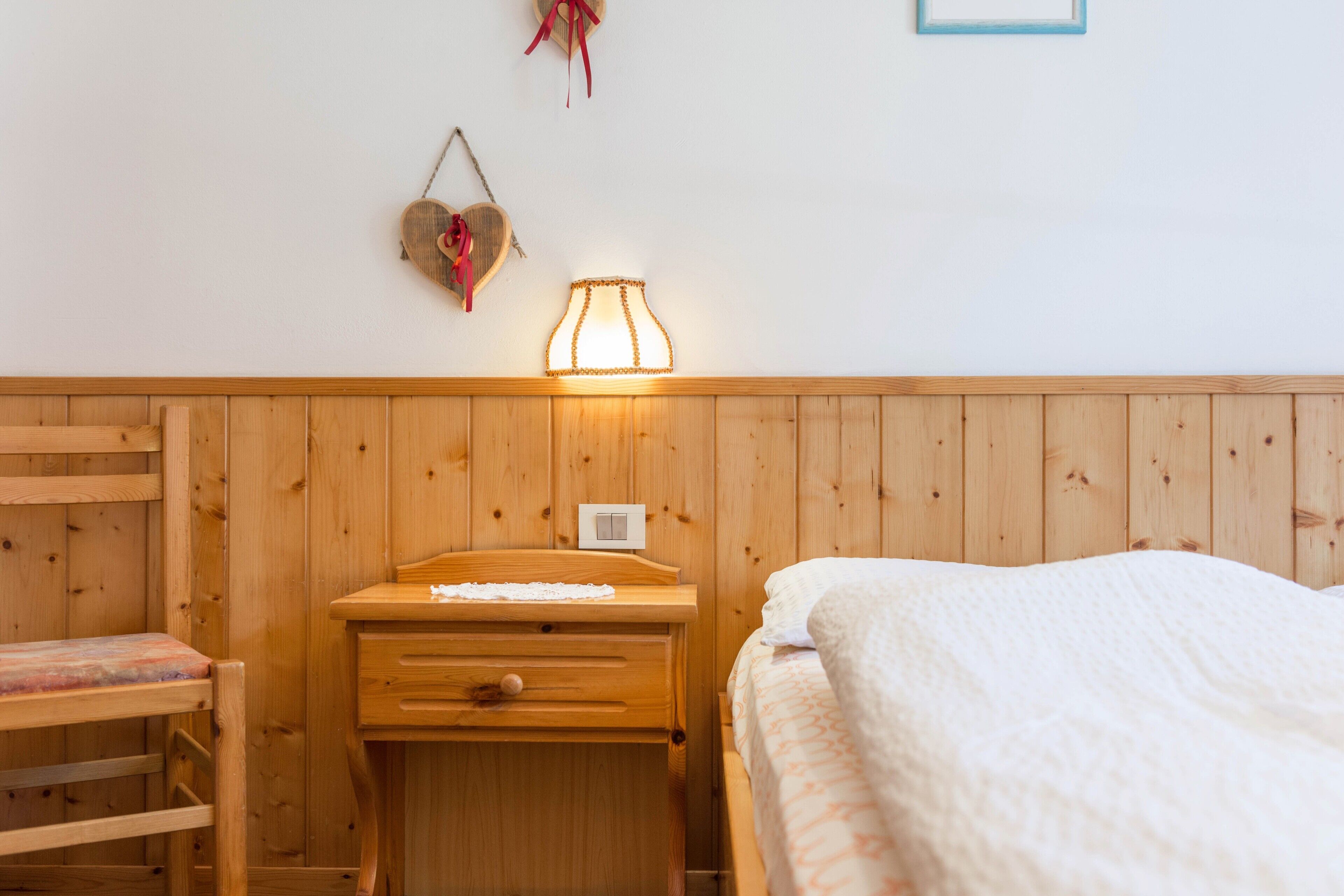 Ein Zimmer mit Holzwänden, einem Bett, einem Schreibtisch und einem Stuhl.