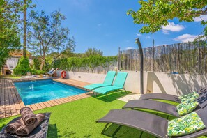 A backyard with a swimming pool, green artificial grass, and lounge chairs. - Vacation Home Casa Gema with Mountain View, Pool, Wi-Fi, Garden & Terrace; Parking on Street Available (Selva)