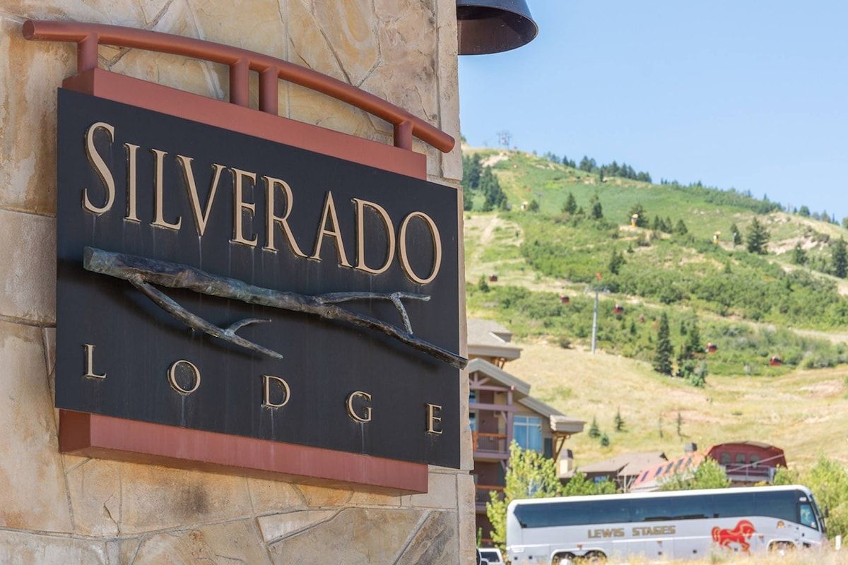 Letrero que dice 'SILVERADO LODGE' con un diseño rústico de rama.