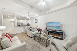 A modern living room with a sofa, coffee table, and a flat-screen TV. - Modern Oasis pool paradise (Cape Coral)