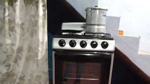 A compact kitchen with a built-in oven and a stovetop. - Aquetzali kin Private House with Pool (Cuautla)
