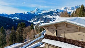 A wooden chalet with a sloped roof, surrounded by snow-covered mountains and a clear sky. - Charming apartment with Mont Charvin view and parking (Notre-Dame-de-Bellecombe)