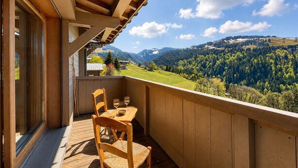 A wooden balcony with a table and chairs, overlooking a mountainous landscape. - Charming apartment with Mont Charvin view and parking (Notre-Dame-de-Bellecombe)