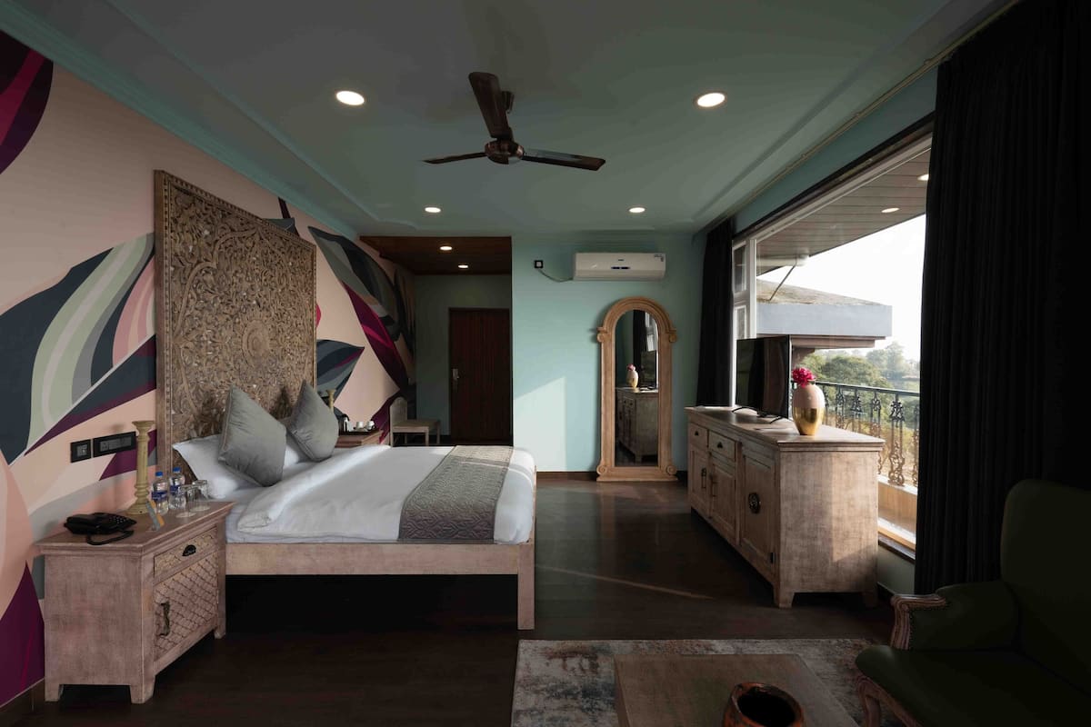A spacious bedroom with a large bed, a ceiling fan, and a view of the outdoors.
