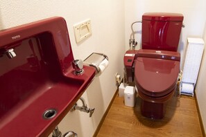 A bathroom with a red sink, toilet, and a paper towel dispenser. - HARMONIA Tokyo Horikiri (Tokyo)