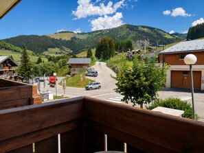 A mountain view with a road leading to a building with a sloped roof. - 3-room apartment at the foot of the slopes with parking and pets allowed (Notre-Dame-de-Bellecombe)