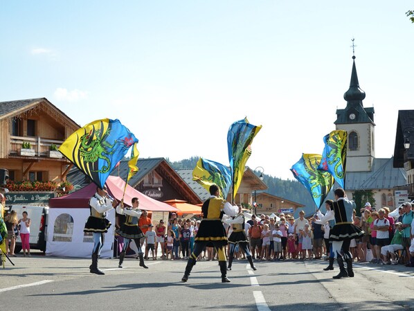 Ein Straßenumzug mit Darstellern in traditioneller Tracht und Fahnen.